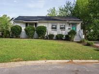 Charming single-story home featuring a well-maintained lawn, lush shrubbery, and a quaint covered front porch at 1116 Holburn Pl, Raleigh, NC 27610