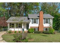 Charming two-story home featuring white siding, a brick chimney, and a well-maintained front lawn at 1120 Shetland Ct, Raleigh, NC 27609