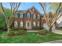 Charming two-story brick home with a well-manicured lawn and lush landscaping at 1216 Caribou Xing, Durham, NC 27713