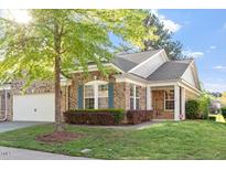 Charming single-story home featuring stone accents, lush landscaping, and a well-manicured lawn at 1307 Seattle Slew Ln, Cary, NC 27519