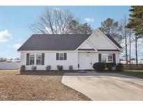 Charming single-story home with a well-maintained yard and a long concrete driveway at 1432 E Stonemason Dr, Fuquay Varina, NC 27526