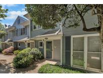 Charming townhome exterior with gray siding, lush landscaping, and inviting front entrance at 1442 Barton Place Dr, Raleigh, NC 27608