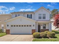 Charming two-story home with a well-manicured front lawn and a two-car garage on a sunny day at 145 Ryder Cup Cir, Raleigh, NC 27603
