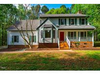 Charming two-story home with a welcoming front porch and vibrant red front door at 15 Pine Ridge, Pittsboro, NC 27312