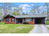 Charming single-story brick home with a covered parking area, neat landscaping, and classic shutters at 1813 Grady Dr, Durham, NC 27712