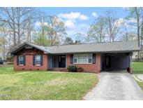 Charming one-story brick house with a well-maintained lawn and cozy carport at 1813 Grady Dr, Durham, NC 27712