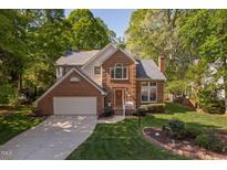 Charming two-story brick home with a well-manicured lawn and an attached two-car garage at 2221 Dungiven Ct, Garner, NC 27529