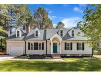Charming home boasts a teal door, dormer windows, black shutters and a well-manicured lawn at 3100 Greenville Loop Rd, Wake Forest, NC 27587