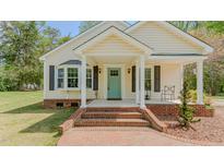 Charming home featuring a welcoming front porch with a bright, light-blue front door at 322 W Hill N Ave, Hillsborough, NC 27278