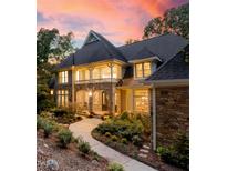 Stunning stone and shingle home featuring a covered porch, manicured landscaping, and a serene walkway under a beautiful sky at 32430 Archdale, Chapel Hill, NC 27517