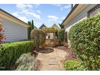 Landscaped backyard with a wooden gate and stepping stone pathway, offering a private and serene outdoor space at 379 Tobacco Farm Way, Chapel Hill, NC 27516