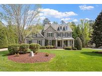 Charming two-story home featuring stone accents, gray siding, manicured lawn, and mature trees at 4213 Summer Brook Dr, Apex, NC 27539