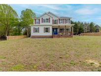 Two-story home featuring red shutters, a covered front porch, and a large front yard at 4228 Nc 42 Hwy, Raleigh, NC 27603