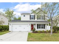 Charming two-story home featuring a two-car garage, red front door, and a well-manicured lawn with landscaping at 4817 Quarryman Rd, Raleigh, NC 27610