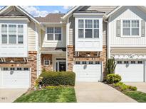 Charming townhome exterior with stone accents, attached garage, and a neatly landscaped front yard at 4924 Amber Clay Ln, Raleigh, NC 27612