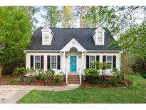 Charming two-story home featuring a manicured lawn, black shutters, and a welcoming turquoise front door at 5911 Mountain Island Dr, Durham, NC 27713