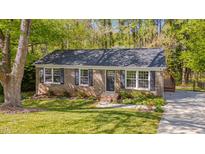 Charming brick home with black shutters, mature trees, and a well-maintained lawn at 6105 Bellow St, Raleigh, NC 27609