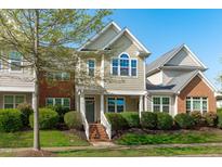 Charming two-story home with manicured landscaping, brick stairs, and a welcoming front porch at 633 Democracy St, Raleigh, NC 27603