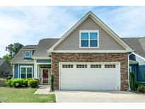 Charming two-story home featuring a stone facade, two-car garage, and manicured lawn at 74 Revelstoke Dr, Garner, NC 27529