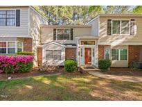 Charming townhome with a brick facade, well-manicured landscaping, and a welcoming front entrance at 7707 Falcon Rest Cir, Raleigh, NC 27615