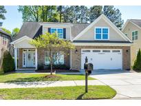 Beautiful brick home featuring a well-manicured lawn, mature tree, and two-car garage at 837 Varina Ln, Fuquay Varina, NC 27526