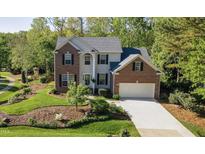 Charming two-story brick home with a well-manicured lawn and attached two-car garage at 906 Ingram Ct, Hillsborough, NC 27278