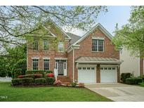 Charming brick two-story home featuring an attached two-car garage and manicured landscaping at 9225 Palm Bay Cir, Raleigh, NC 27617