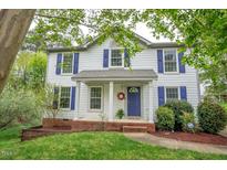 Charming two-story home featuring a welcoming front porch and blue shutters at 104 Dilworth Ct, Cary, NC 27513