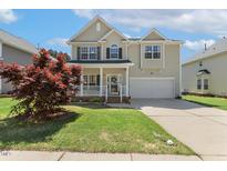 Charming two-story home with a well-manicured lawn, attached garage, and inviting front porch at 1127 Woodlands Creek Way, Apex, NC 27502