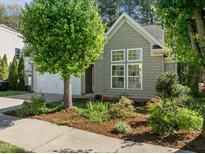 Charming home featuring mature landscaping, neutral siding, and a welcoming entrance with large windows at 1322 Pebble Creek Xing, Durham, NC 27713