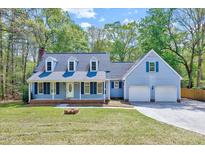 Charming two-story home with a well-manicured lawn and a welcoming two-car garage at 1433 Andersonwood Dr, Fuquay Varina, NC 27526