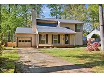 Charming two-story home with a neutral exterior, attached garage, and mature trees at 1517 Laughridge Dr, Cary, NC 27511