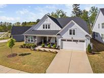 Charming home features a two-car garage, stone accents, covered porch and manicured landscaping at 158 Sea Foam Dr, Raleigh, NC 27610