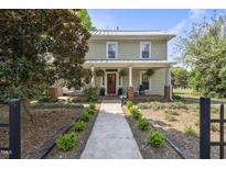 Charming two-story home featuring a welcoming front porch with swing and meticulous landscaping at 205 W Moore St, Apex, NC 27502