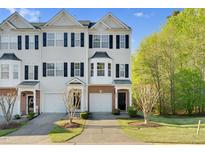 Charming townhome with blue shutters, well-manicured lawn, and a one car garage at 2604 Wyntercrest Ln, Durham, NC 27713