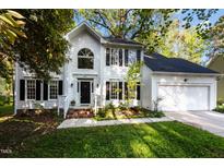 Charming two-story white home featuring a manicured lawn and two-car garage at 3514 Shady Creek Dr, Durham, NC 27713