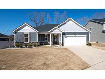 Charming single-story home with gray siding, stone accents, and a well-manicured front yard at 403 Lagoon Ln, Mebane, NC 27302