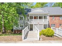 Charming condo featuring a covered entryway with white railing and a well-maintained yard at 407 Gooseneck Dr # A2, Cary, NC 27513