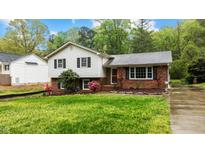 Charming two-story home featuring a brick and vinyl facade with a well-maintained front yard and mature landscaping at 505 Forest Rd, Oxford, NC 27565