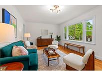 Bright living room with hardwood floors, stylish furniture, and a large window offering a view of the outdoors at 513 Hugo St, Durham, NC 27704
