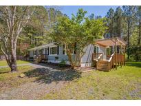 Charming home with a light blue exterior, a pergola deck, and a gravel driveway at 5604 Bobcat Rd, Chapel Hill, NC 27516