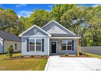 Charming exterior view of this light blue home, featuring a well-manicured lawn and inviting facade at 621 Ray St, Selma, NC 27576