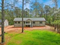 Charming ranch-style home with a welcoming front porch and a partially wooded front yard, perfect for outdoor relaxation at 7120 Guess Rd, Hillsborough, NC 27278