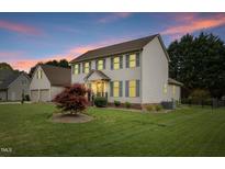 Charming two-story home with manicured lawn and mature trees during the evening at 803 Driftwood Dr, Gibsonville, NC 27249