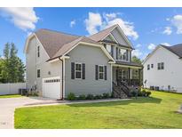 Charming two-story home with attached garage, manicured lawn, and inviting covered porch at 810 Mulberry Rd, Spring Hope, NC 27882
