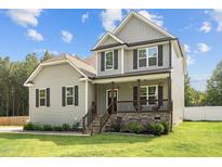 Charming two-story home with a covered front porch, black shutters, and a well-manicured lawn at 810 Mulberry Rd, Spring Hope, NC 27882