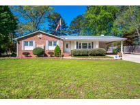 Charming single-story home with brick accents, manicured lawn, and a covered carport on a sunny day at 926 Allister Rd, Durham, NC 27703