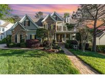 Beautiful home with stone and siding, lush lawn, manicured landscaping, and a brick walkway at 944 Alden Bridge Dr, Cary, NC 27519