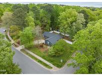 Inviting home boasts mature trees, lush landscaping, fenced yard, and corner lot at 1015 Castalia Dr, Cary, NC 27513