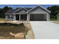 New construction with gray siding, an attached two-car garage, and a concrete driveway at 107 Tee Dr, Selma, NC 27576